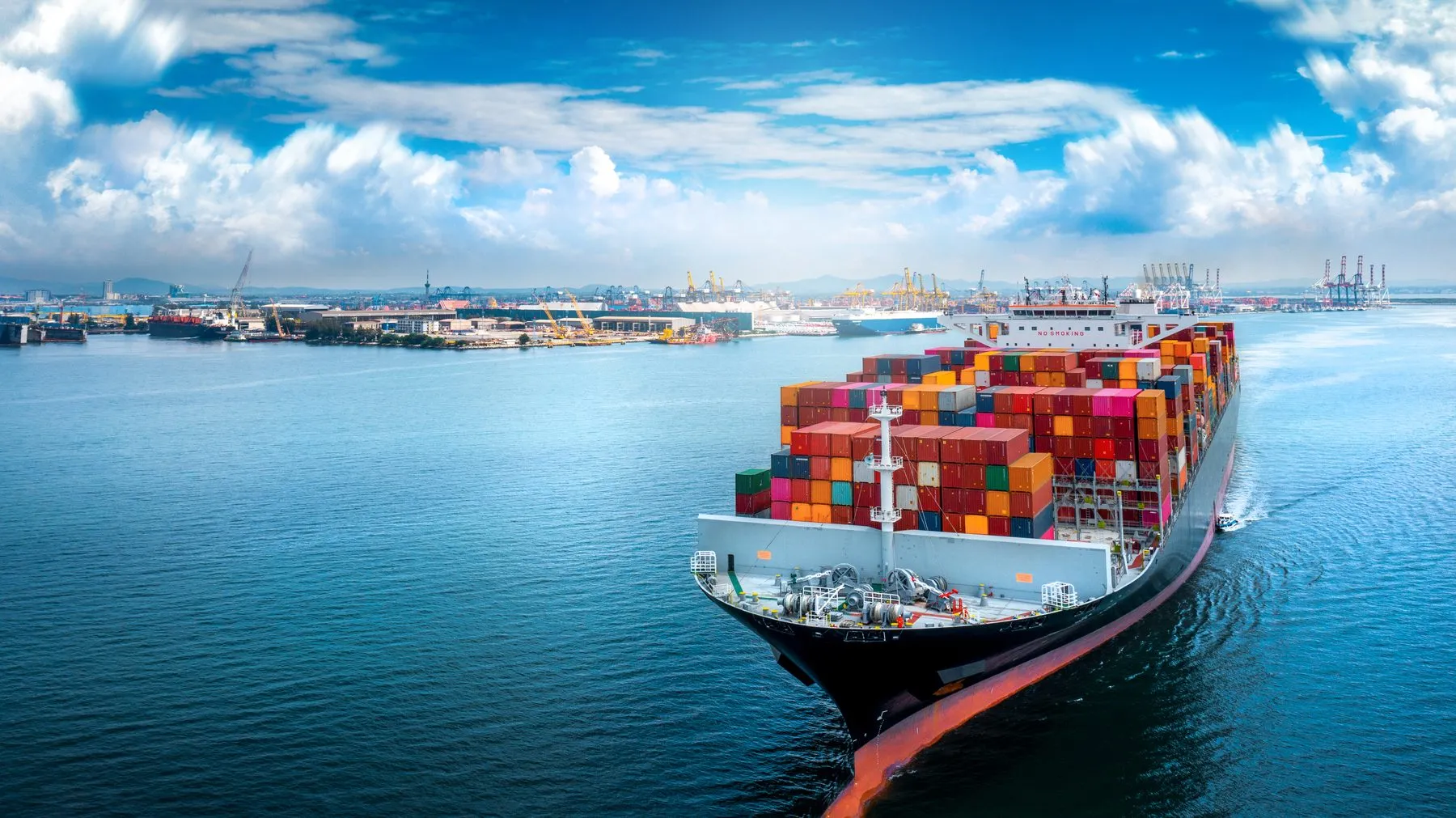 A loaded container ship leaving port on a clear day